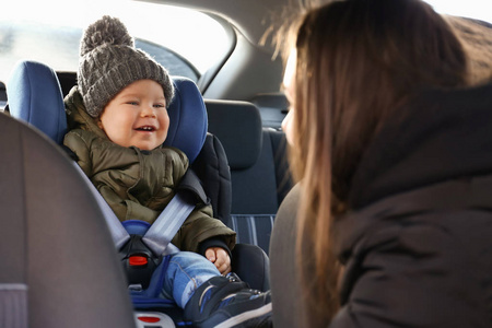 女汽车司机和她儿子扣在婴儿座椅上
