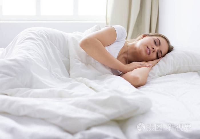 美丽的女孩睡在卧室里,躺在床上