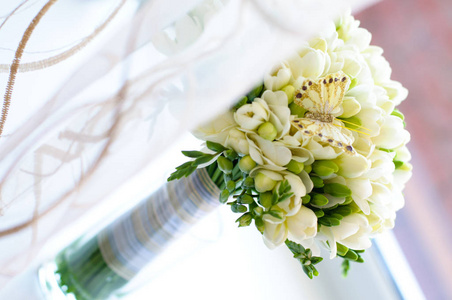 带有装饰蝴蝶的白色自由花的婚礼花束。