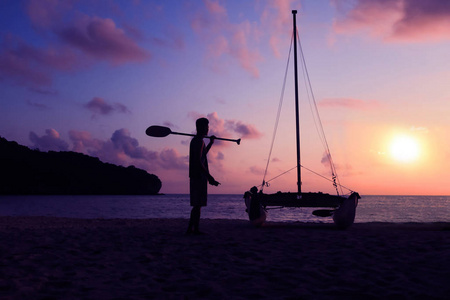 在美丽的日出清晨，海滩上的霍比猫或双体船在海滩上剪影，亚洲用桨和帆船在海滩上航行