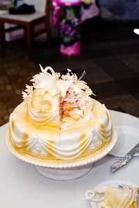 一个白色的婚礼蛋糕，上面装饰着金色的花和白色的天鹅。