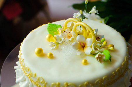 用可食用的花和结婚戒指装饰的婚礼蛋糕。