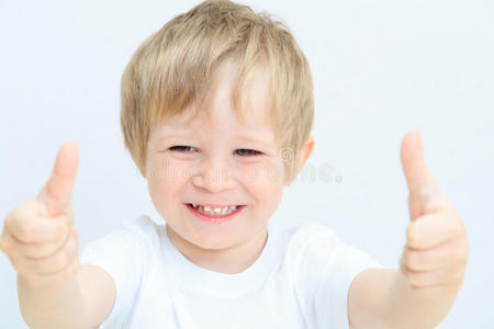 快乐的小男孩竖起大拇指在白色