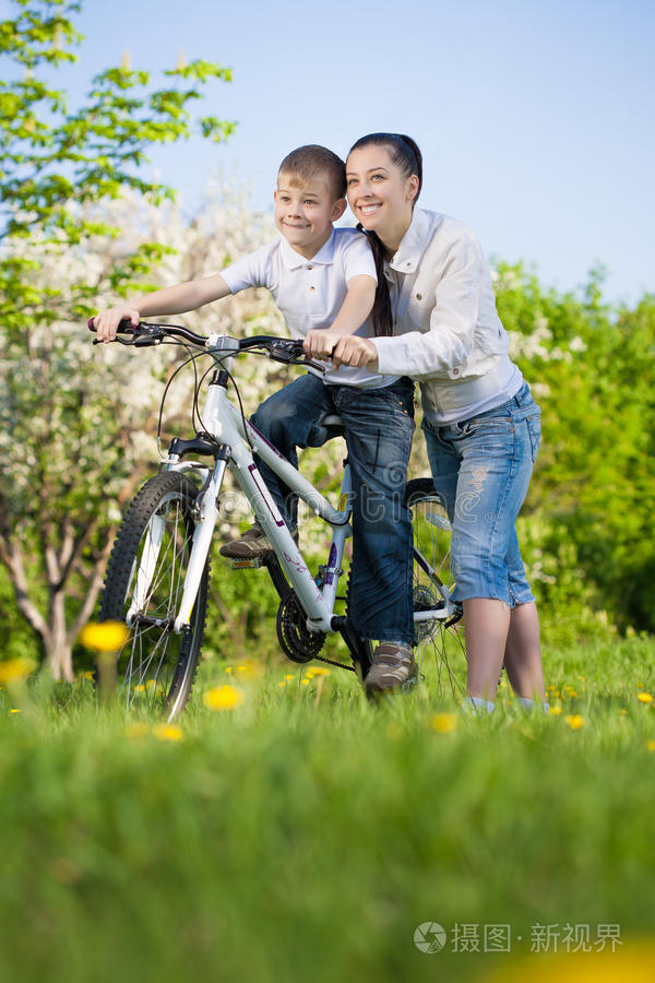 快乐的男孩和妈妈一起骑自行车