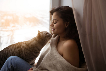 可爱的女孩和窗户边的一只大猫
