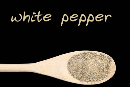白色胡椒在木勺上隔离黑色背景