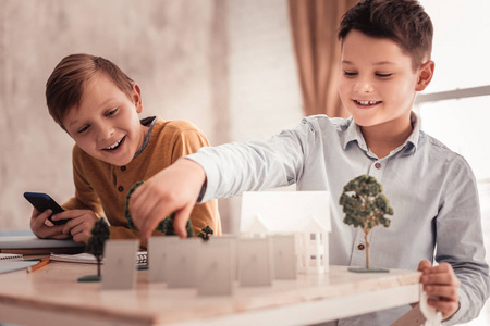 两个好奇的小学生们建造独立房屋的模型