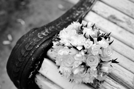 一束新娘在白色长凳上。 漂亮的婚礼花束。 黑白的。