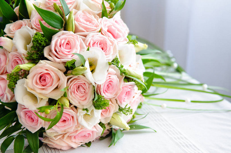 一束带粉红色玫瑰的新娘放在桌子上。