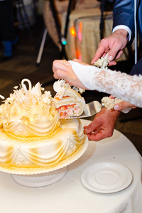 新婚夫妇切了一个漂亮的白色婚礼蛋糕。