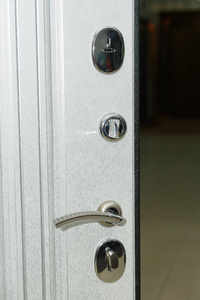 门是白色的。木雕。内部锁设计。钥匙孔。金属门把手。防堡装甲门。金属门。门的设计..小洞。