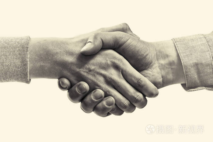两个伙伴之间坚定的握手.隔离背景上的黑白图像.