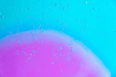 水油泡粉绿色背景..宏观拍摄美丽的水和油泡背景，小和大泡泡。