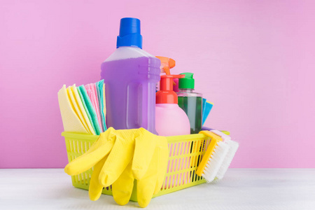 放置在黄色的液体和粉末产品篮子里，在粉红色的背景下在室内清洗