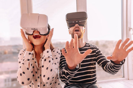 在虚拟现实中旅行的丈夫和妻子感到惊讶