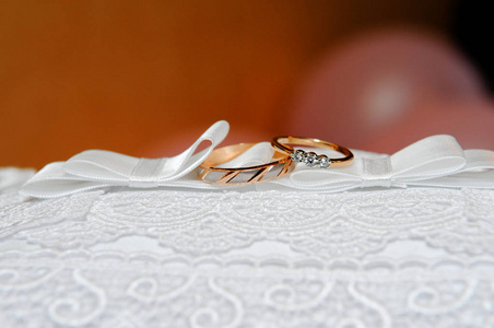 白色垫子上的金色结婚戒指。 结婚纪念日。