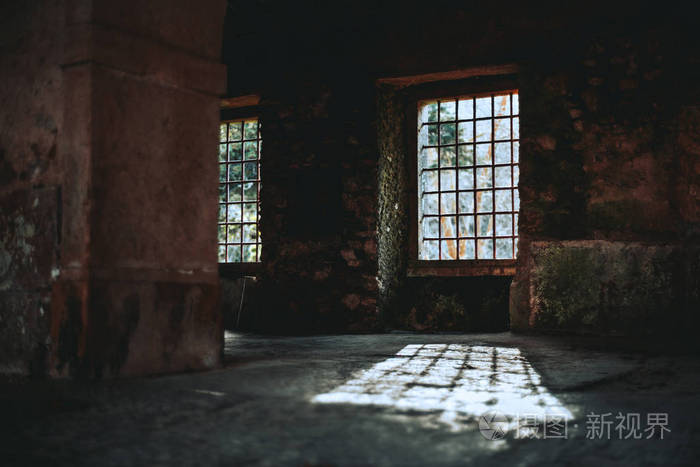 一个废弃的古董空间的阴暗的大气内部,里面有空的窗洞,里面有金属条