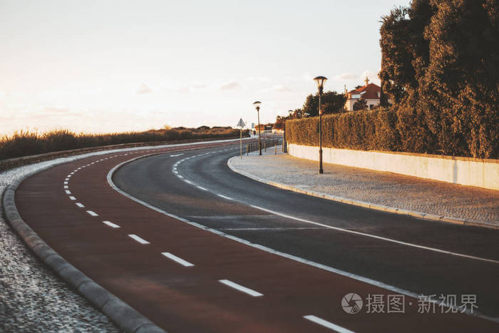 一条空旷整洁的双向道路向右转弯道路标志着自行车道灯笼和人行道在