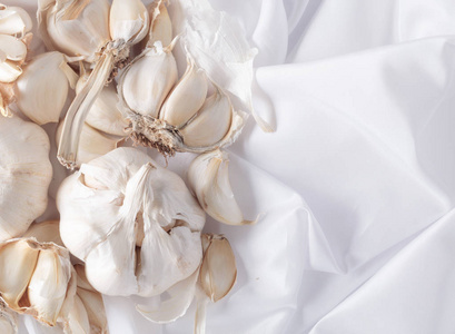 灯泡和大蒜丁香在白色纺织品顶部的视图。