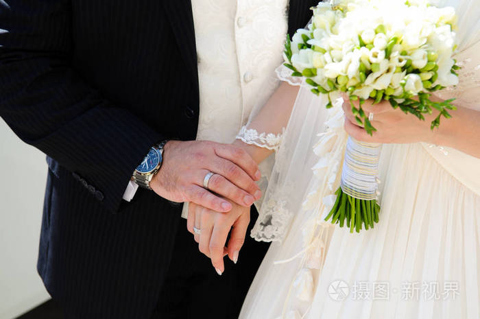 新娘和新郎在公园散步时牵手. 夏天的婚礼.