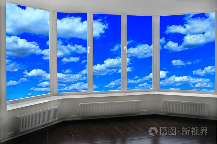 房间的窗户俯瞰蓝天白云。 现代窗户与天空全景。 从窗户看到的天堂景观 现代室内的细节。 房间窗户设计