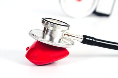 听诊器，红色心脏在白色桌子上。医疗配件与复制空间。