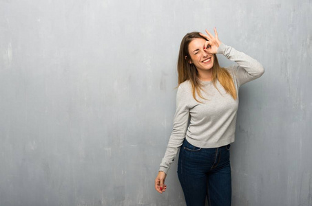 有质感的墙上的年轻女人制造滑稽和疯狂的面部情绪