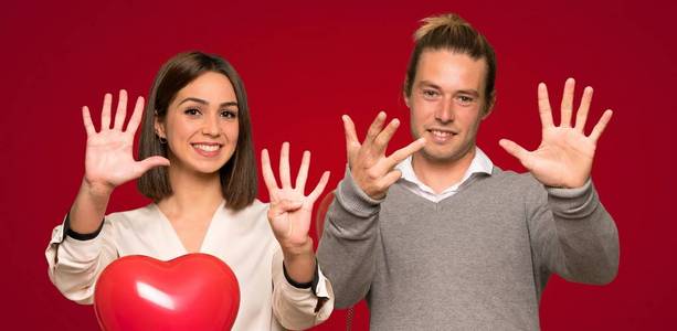 情人节的一对夫妇数着九个手指在红色的背景上