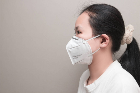 视图关闭美丽的亚洲妇女戴白色防护n95防尘口罩在绿叶背景与复制空间