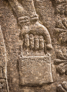 亚述墙浮雕的翅膀天才细节与一只手。 美索不达米亚楔形古雕刻面板。 中东古代亚述和苏美尔文明文化的遗迹。