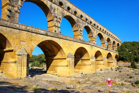 年轻女子站在法国南部的渡槽桥附近。 它是所有高架罗马渡槽中最高的。