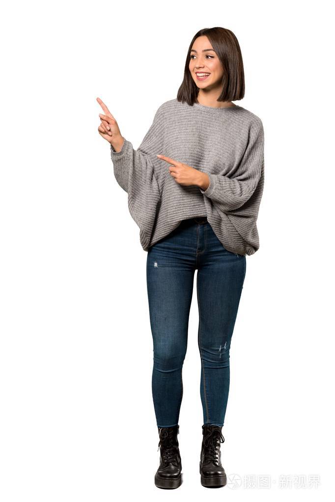 一个年轻女子用手指指着一侧的白色背景的完整镜头