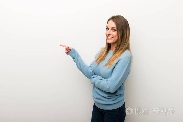 金发女人在孤立的白色背景手指在侧面的位置