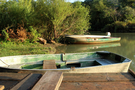 清晨，在佐治亚州河边的船站，一条条古老的绿色木船