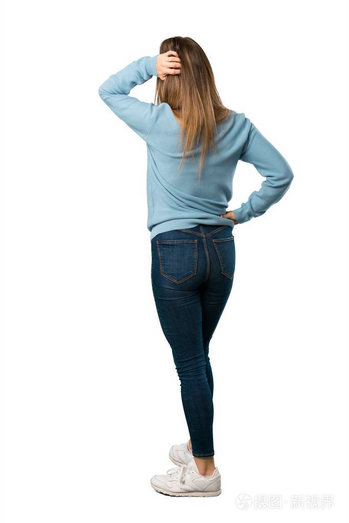 全身的金发女人背着蓝色衬衫回头看在白色背景上挠头