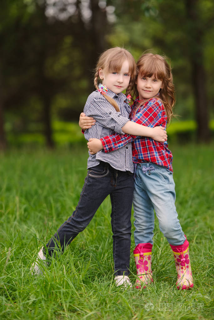 两个女孩拥抱对方在绿色