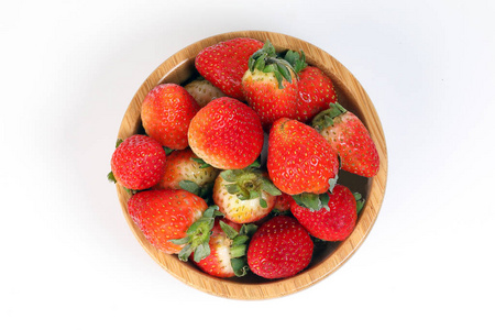 白色背景的木碗中的草莓