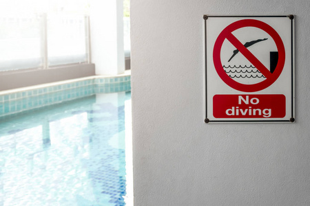 在模糊的游泳池的池畔警告没有潜水标志