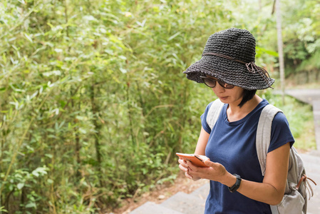 户外徒步旅行时使用手机的女人