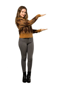 一个穿着棕色毛衣的少女在白色背景上插入广告的完整镜头