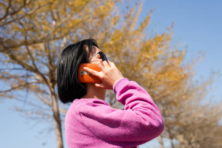 成熟的亚洲美女在户外用手机聊天