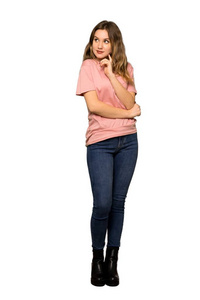 一个穿着粉色毛衣的少女的完整镜头，她认为一个想法是把手指指向孤立的白色背景