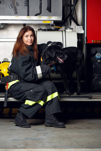 坐在消防车背景上的年轻女子消防队员的图片