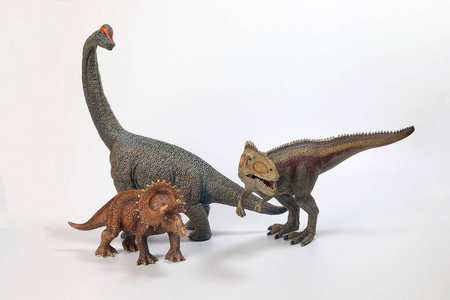 白色背景下的三龙腕龙恐龙玩具雕像