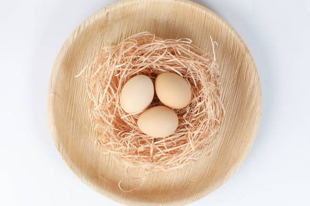 白色背景下巢篮中的鸡蛋