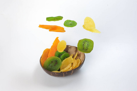 干保存的绿色猕猴桃成熟的水果片五颜六色的甜黑色大理石石板背景椰子壳碗飞升下垂