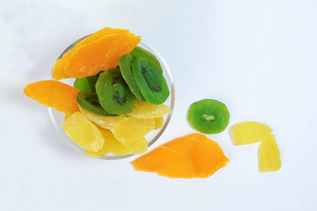 干燥保存的绿色猕猴桃凤梨成熟的水果片，玻璃碗里有五颜六色的甜