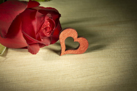 红色玫瑰和激光切割红色木制心形在轻木表面背景的爱和浪漫的概念