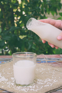 大米牛奶与米粒一起装在瓶子里。 替代类型的牛奶。 纯素非牛奶。 无乳糖牛奶和非奶饮料。 乳糖不耐受症。 健康的食物。
