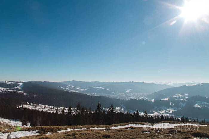 风景秀丽的冬季山景和蓝天背景下明亮的太阳
